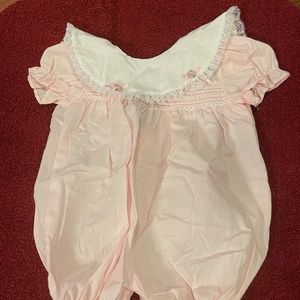 Pink one-piece short sleeve summer outfit with white collar, bordered by lace.